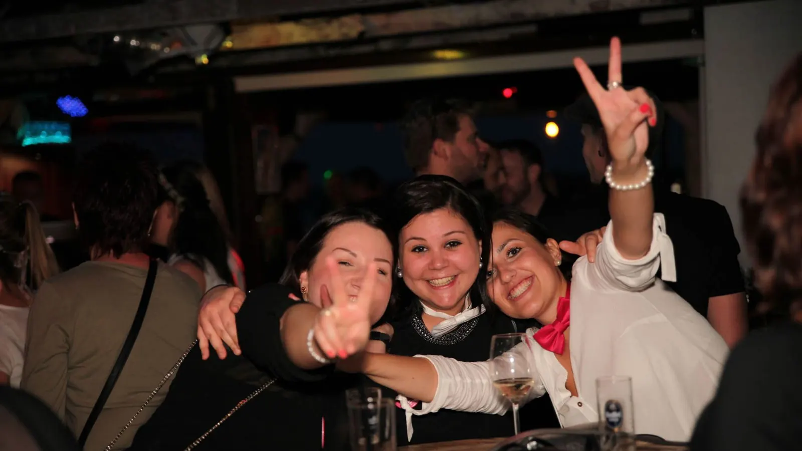Three women celebrating on board in the evening